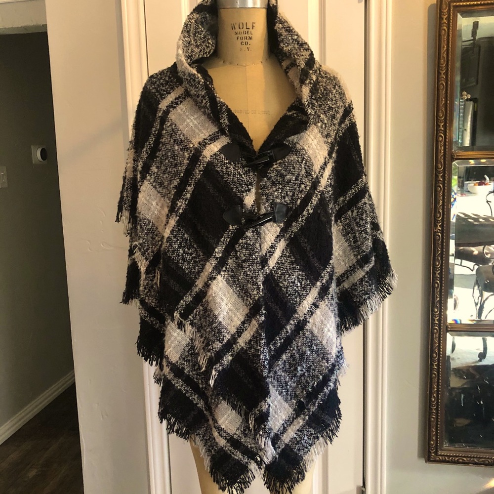 Sweater cape with leather horn closures.